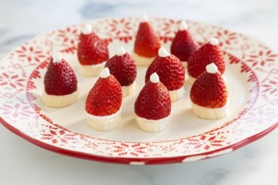 Strawberry santas on red and white christmas plate.