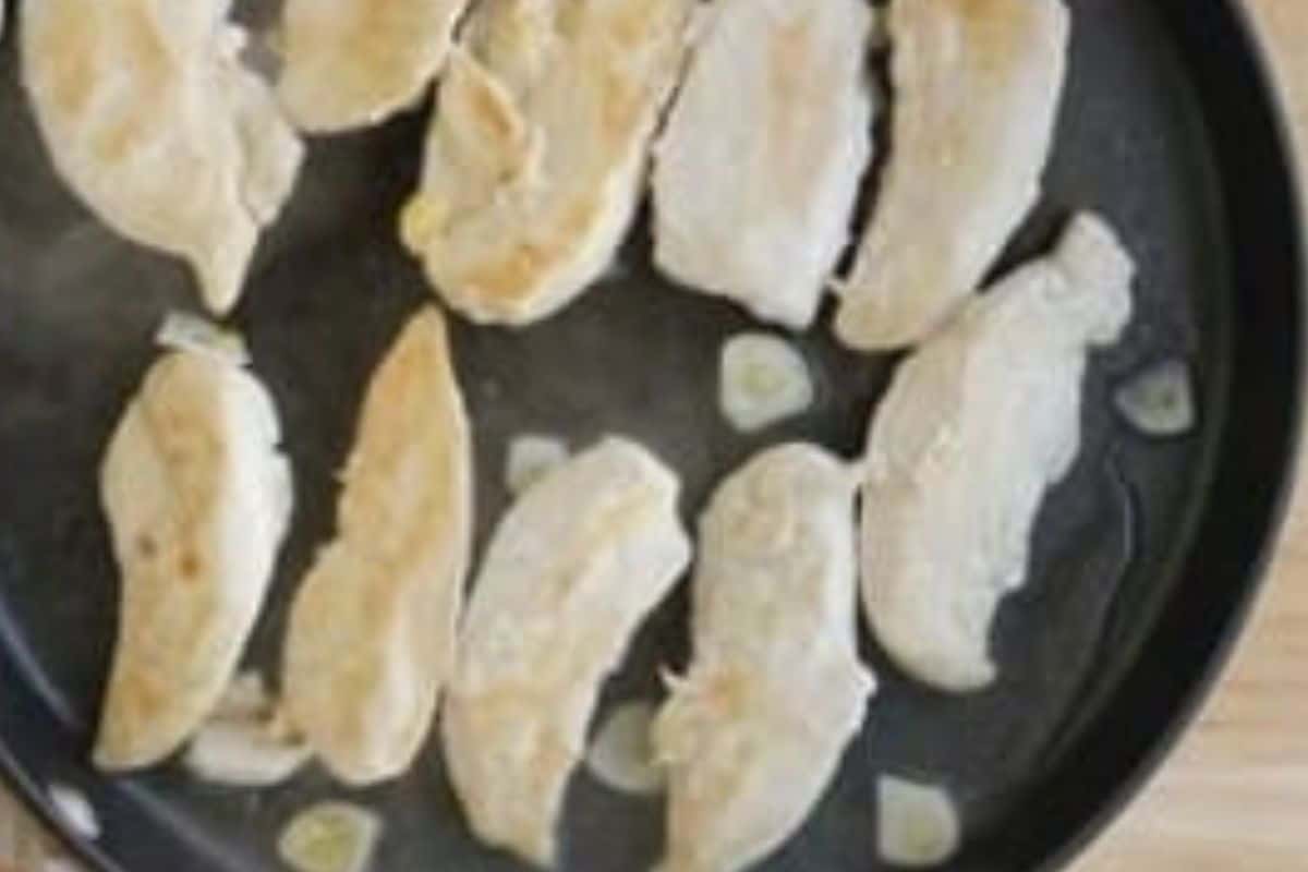 Chicken in pan for pan seared chicken.