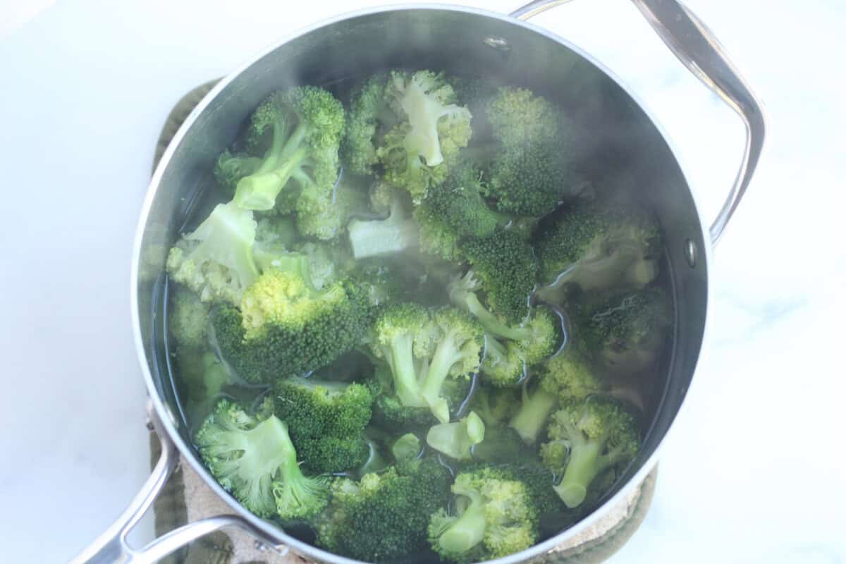 Boiled broccoli in pot of water on stove.
