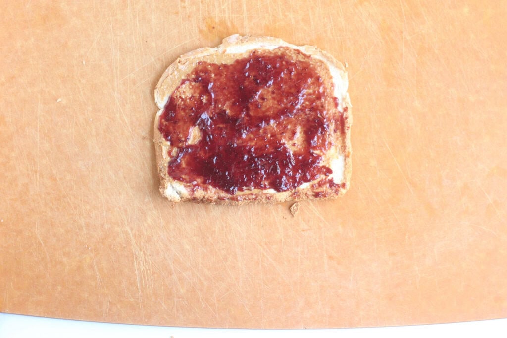 Bread with jelly spread on it for sandwich roll up.