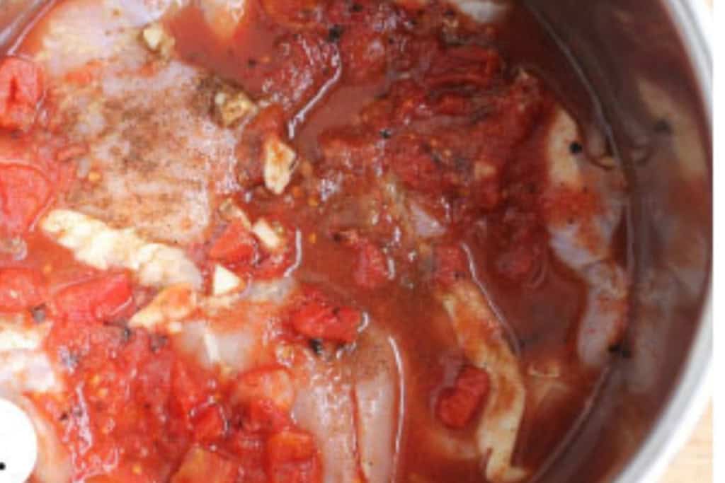 Instant pot with butter chicken inside before cooking.