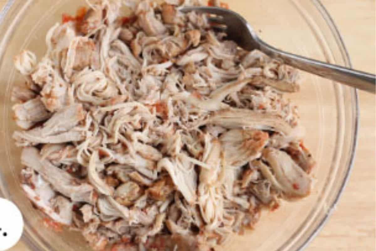 Shredding cooked chicken for butter chicken.