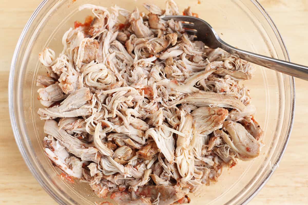 shredded chicken in a bowl with fork. 
