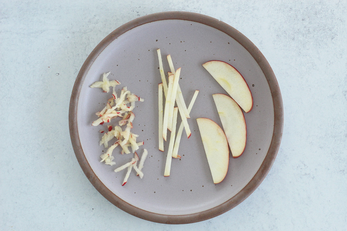 raw apples for baby on purple plate