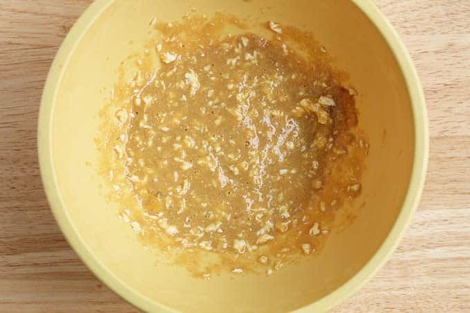 Wet ingredients for chocolate chip cookie cake in yellow bowl.