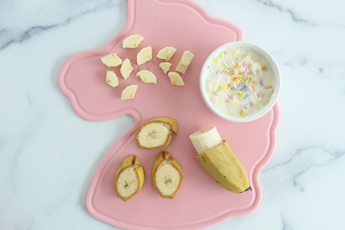 bananas cut up for baby on pink cutting board