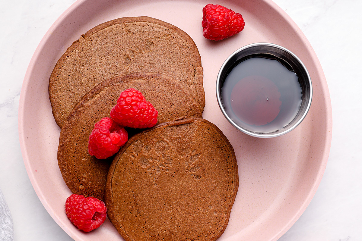 chocolate pancakes with raspberries on plate