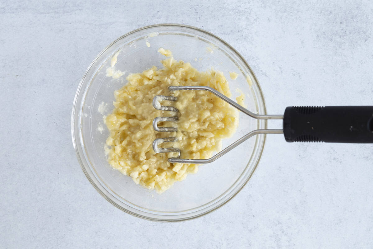 mashing banana in glass bowl.