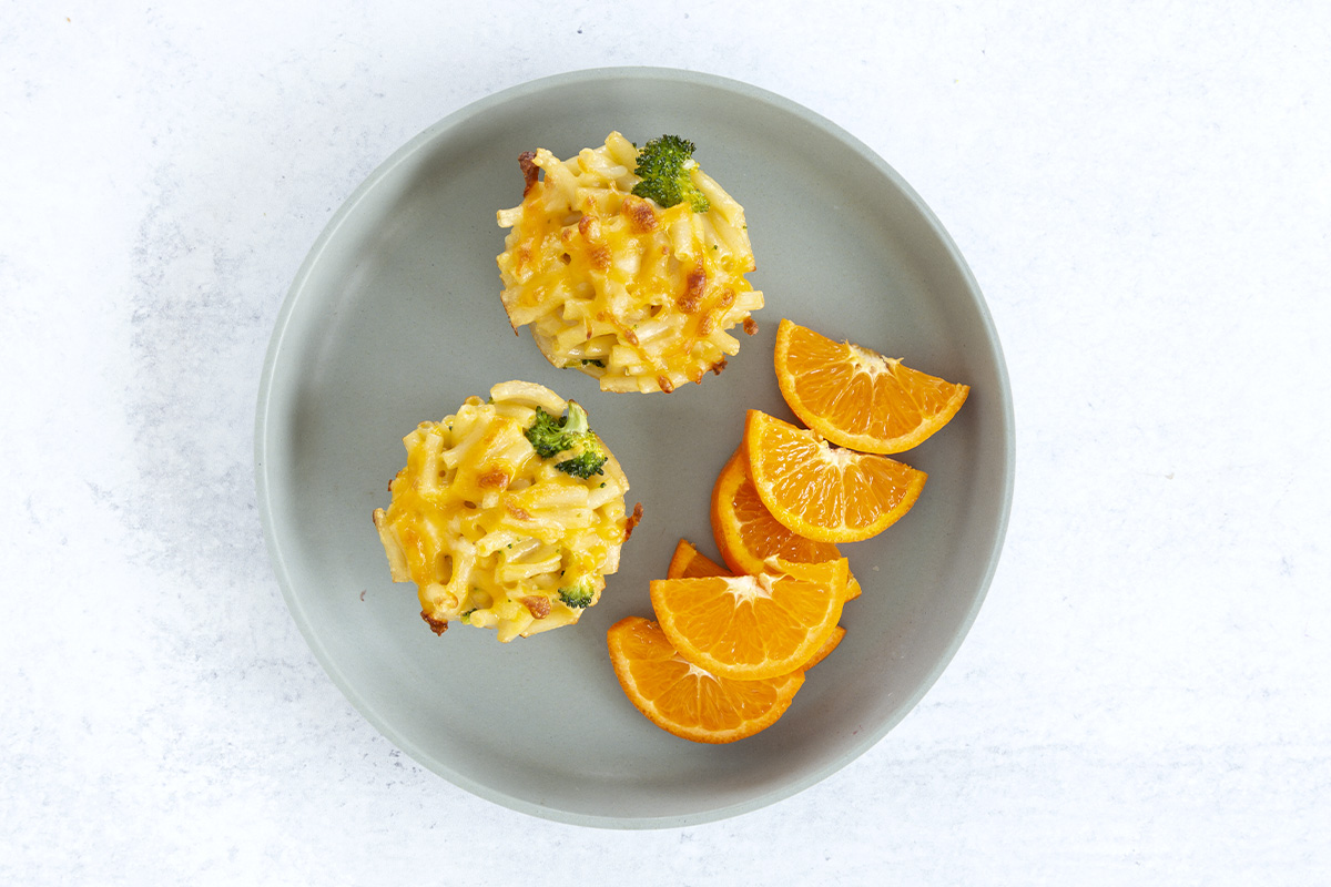 mac and cheese bites on plate with orange slices