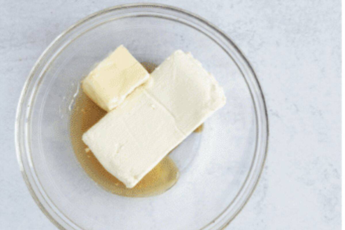 Ingredients for cream cheese frosting in glass bowl before mixing.
