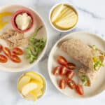 hummus wraps on white plates with apple slices