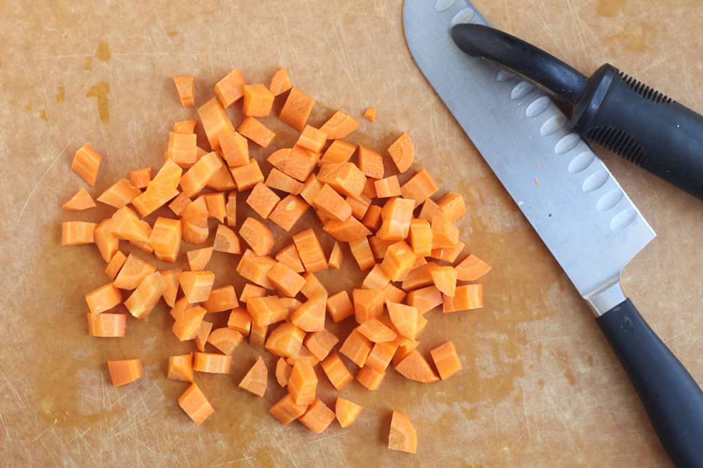 Cutting carrots into cubes for carrot puree.