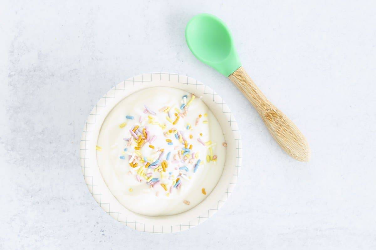 plain yogurt in baby bowl with natural colored sprinkles