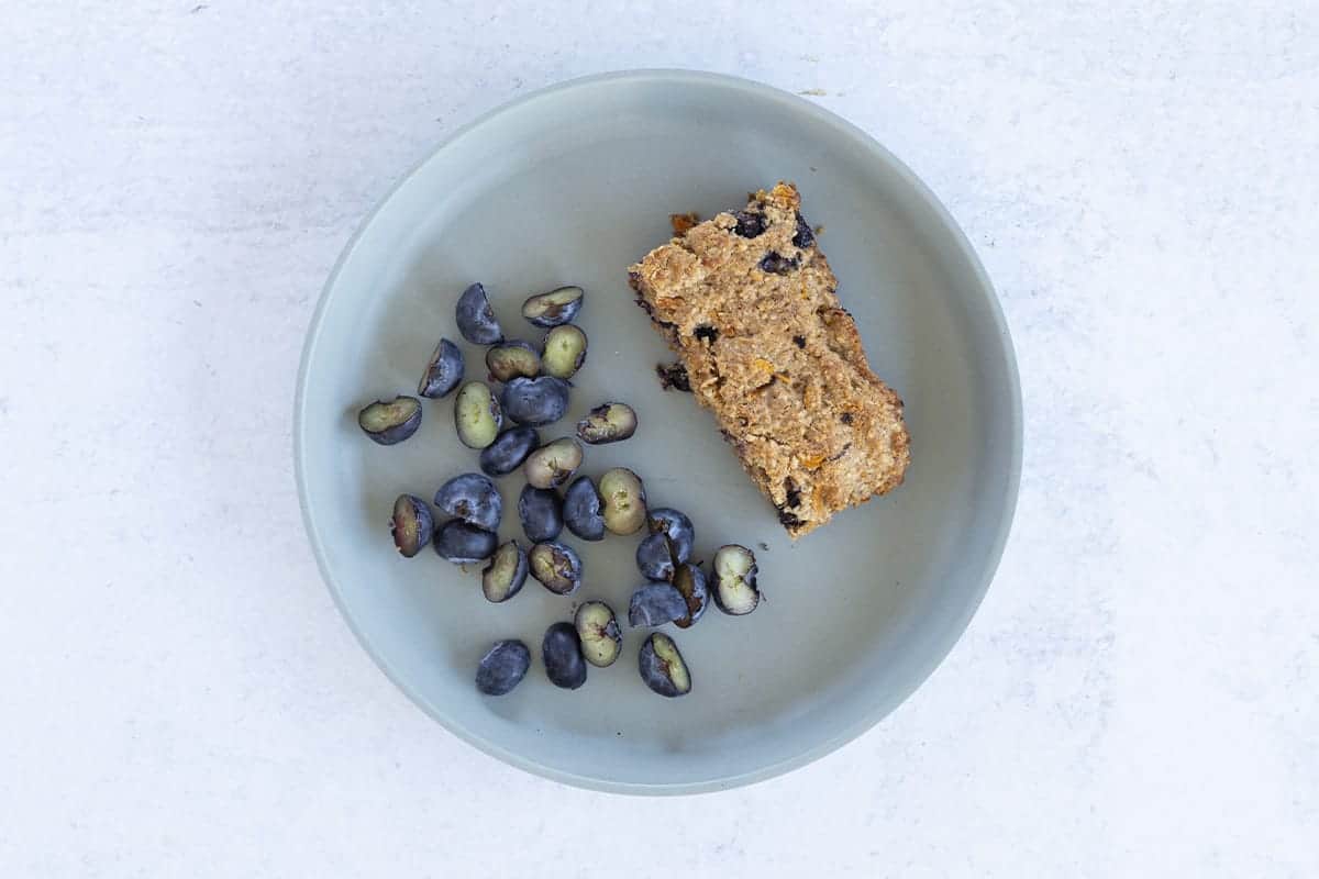 oatmeal bar on plate with halved blueberries