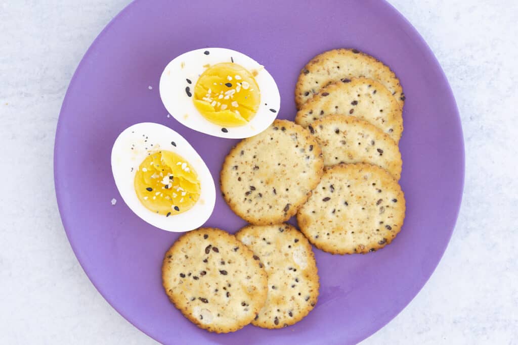 hard cooked eggs and crackers on purple plate