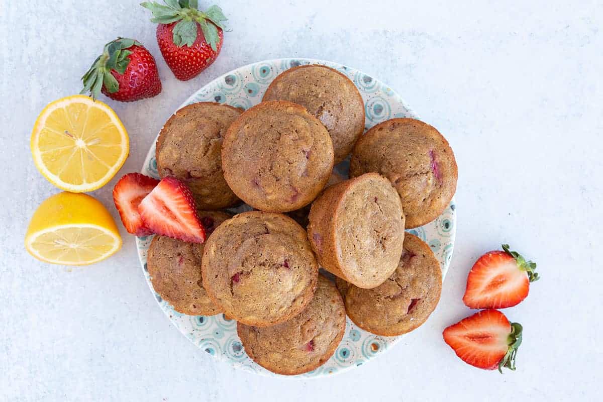 strawberry muffins on plate with berries and fresh lemon.