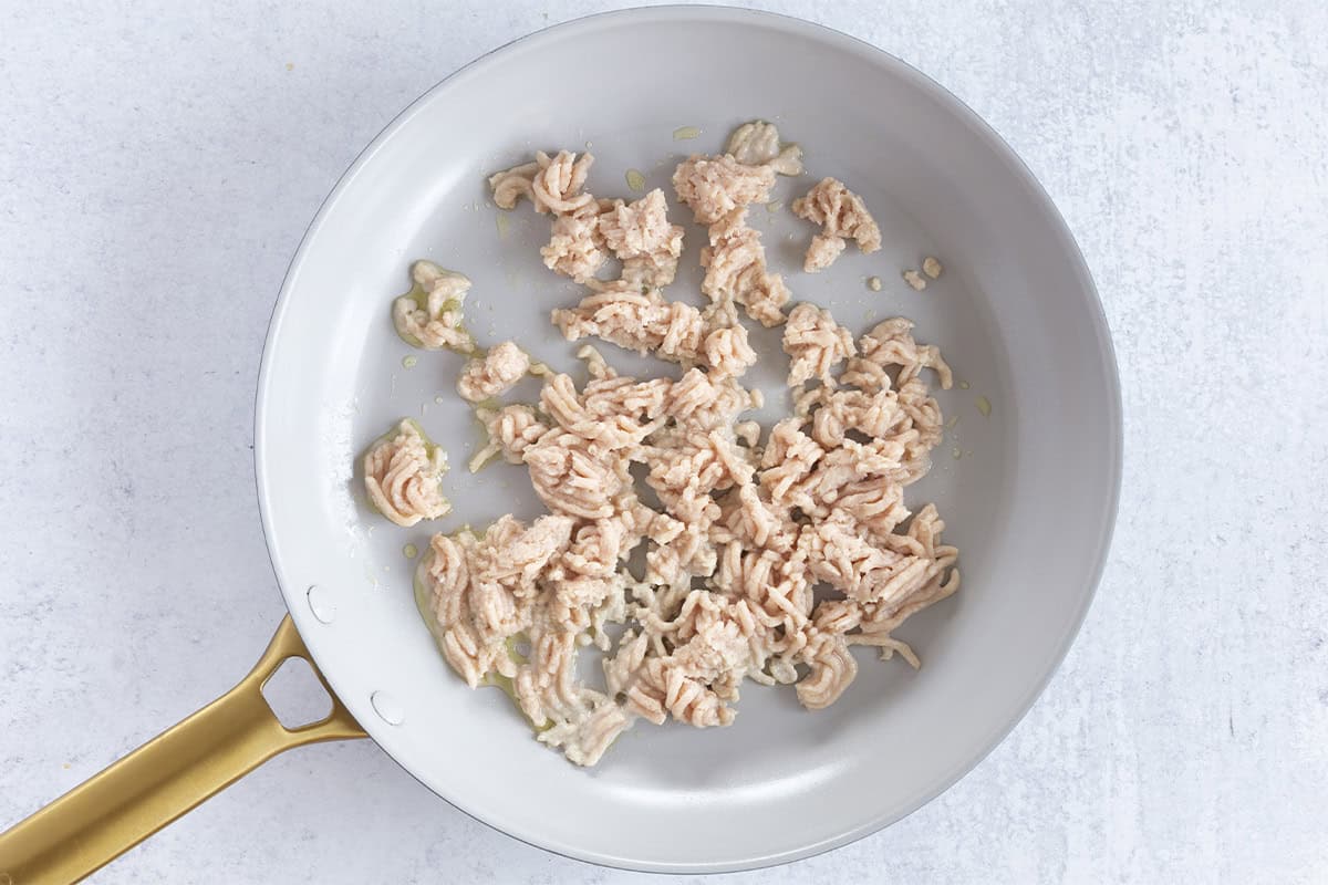 Ground chicken in frying pan for chicken puree.