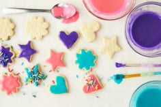 sugar cookies with frosting and sprinkles on surface.