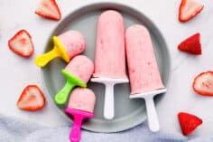 strawberry greek frozen yogurt pops on gray plate.