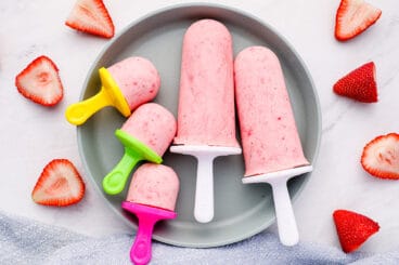 strawberry greek frozen yogurt pops on gray plate.