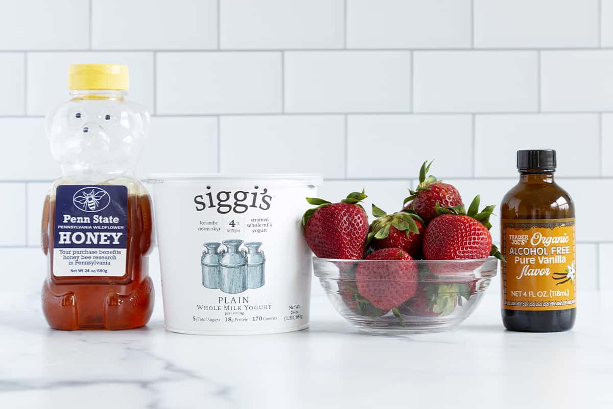 ingredients for strawberry yogurt drink on countertop