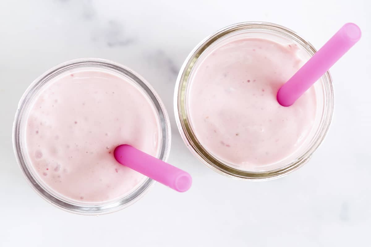 strawberry yogurt drink in two glasses with straws