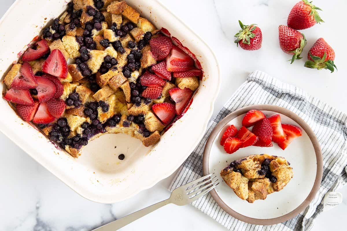 baked french toast casserole recipe on countertop with berries.