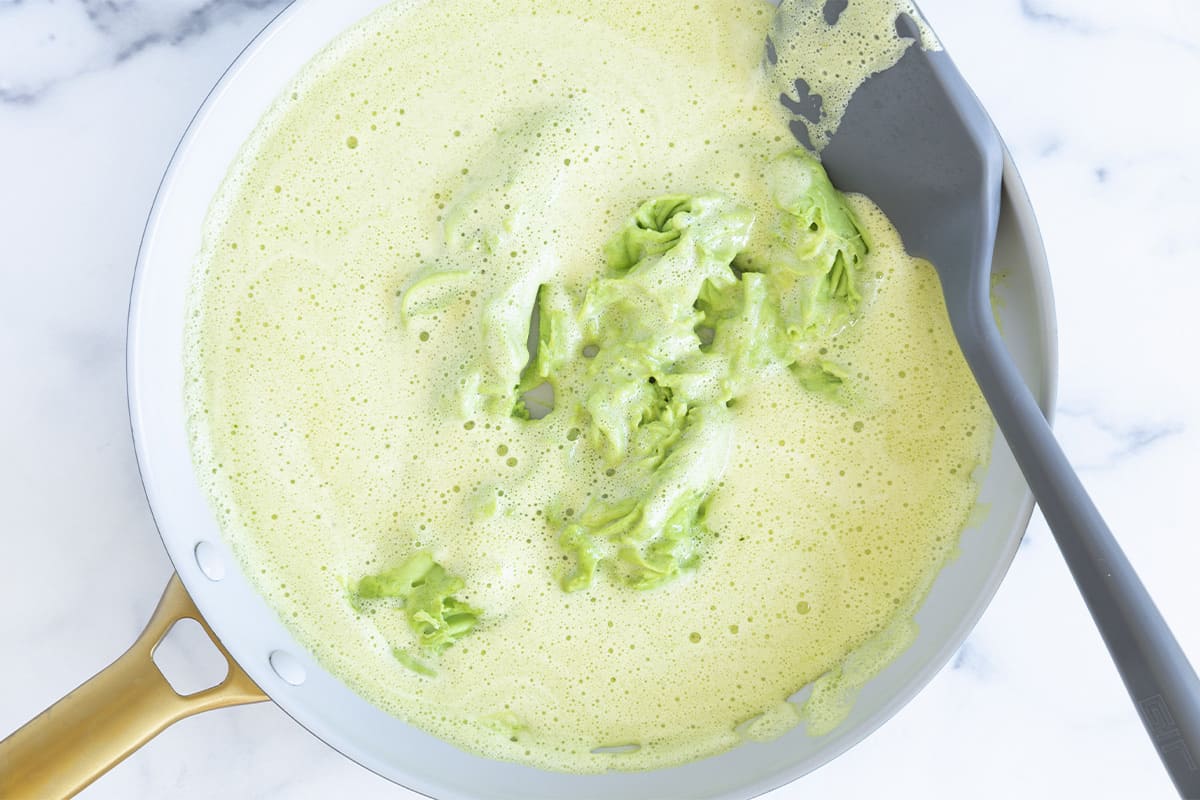 Spinach egg mixture cooking in a pan.