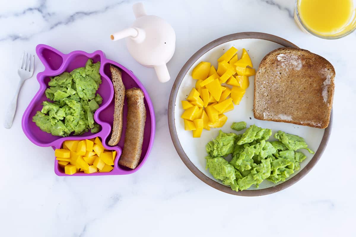 Spinach eggs with fruit and toast on two plates