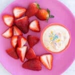 yogurt dip on plate with strawberries.