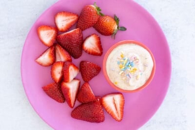 yogurt dip on plate with strawberries.