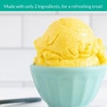 Mango sorbet in blue bowl on countertop with spoon pin