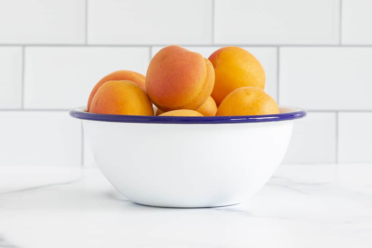 whole apricots in white bowl for apricot baby food