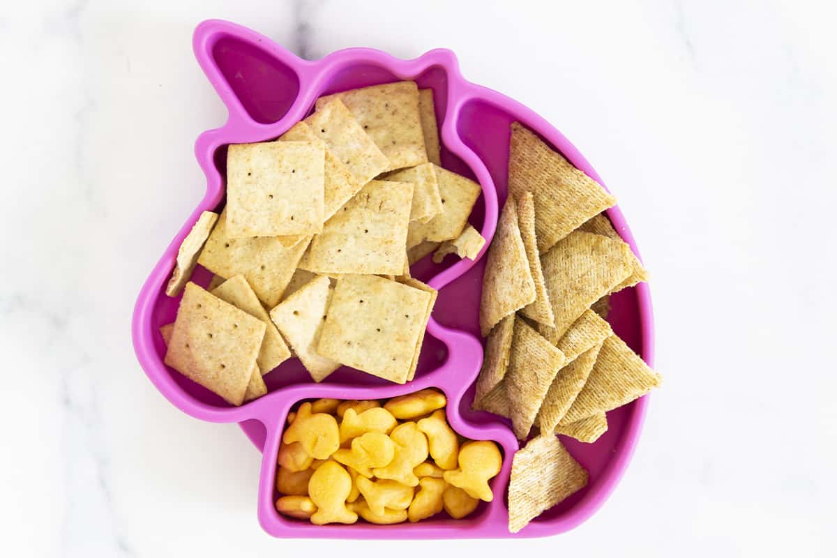 Various crackers for baby in unicorn plate