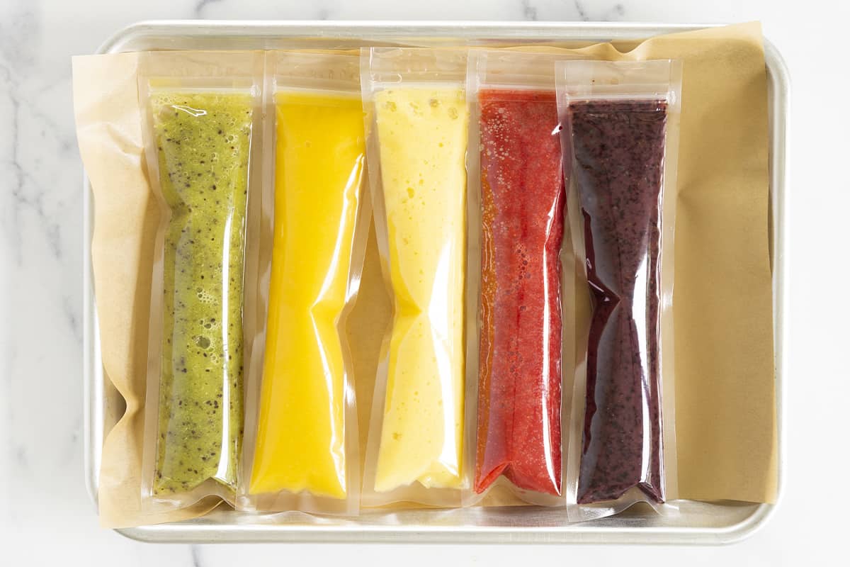 5 ice pops in different colors on parchment paper 