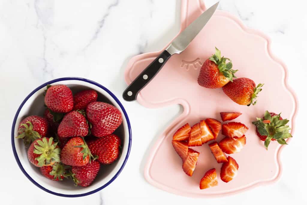 dicing fruit on pink cutting board.