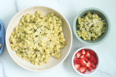 Zucchini pasta on counter in two bowls with side of strawberries
