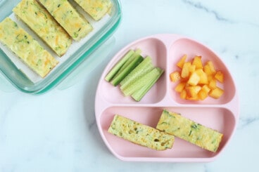 Zucchini slice with veggies on pink kids plate