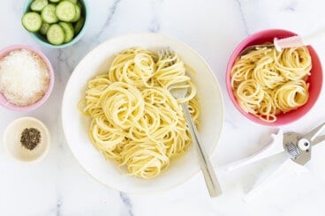 buttered noodles in two bowls with sides
