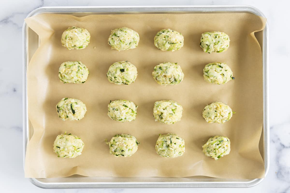 zucchini tots on parchment paper before baking