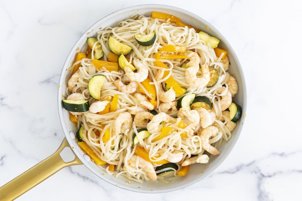 Shrimp and noodles in pan.
