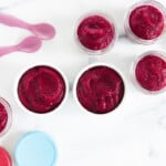 beets baby food in various containers with spoons and lids