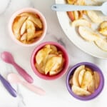 cinnamon apples in three bowls and pan with spoons.