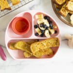 French toast sticks on kids plate with sides.
