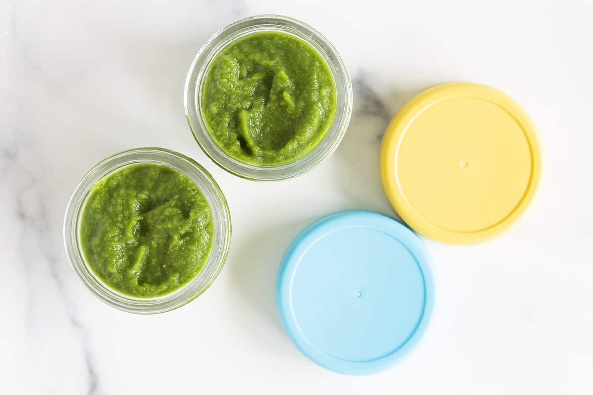 Green bean baby food in two glass jars with lids.