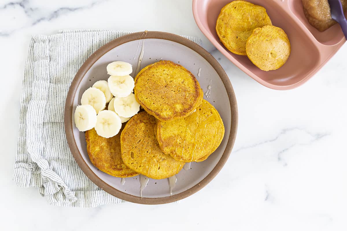 pumpkin pancakes on plate with banana slices.