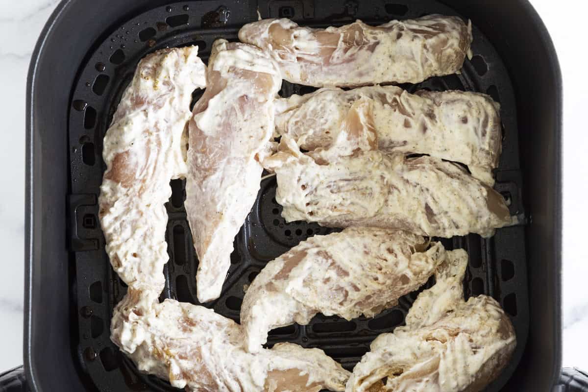 Yogurt chicken in the air fryer before cooking.