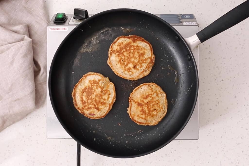 cooked apple pancakes in pan.