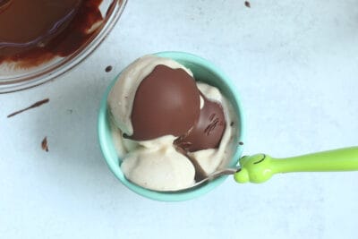 banana ice cream with magic shell in teal bowl.