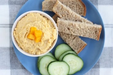 butternut squash hummus in white bowl with dippers.